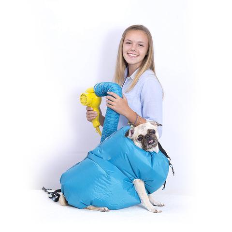 Teen girl using a bright yellow dryer and blue air hose to inflate a blue pet grooming bag around a small pug.