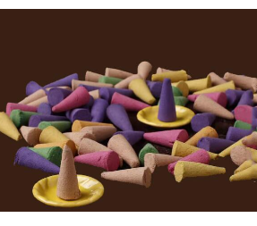 Assorted colorful incense cones in shades of purple, yellow, pink, and tan, with two cones standing on yellow saucers.