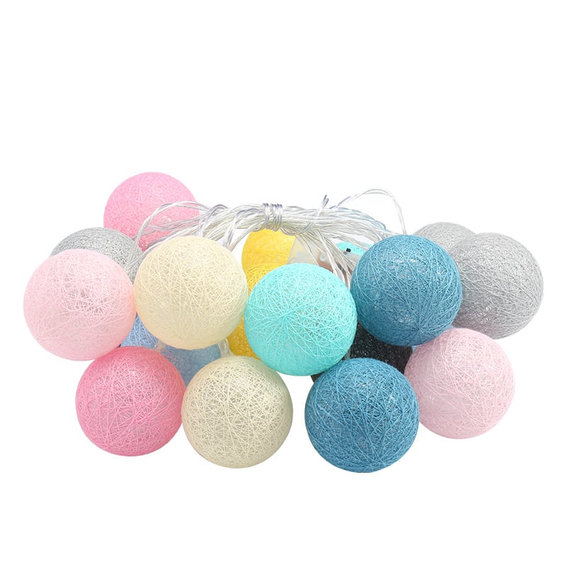 String of spherical lanterns made of pastel and neutral-toned cotton thread, featuring a decorative woven texture.