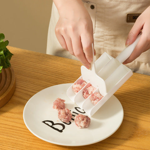 White plastic three-slot meatball maker tool placing raw meatball portions onto a plate.