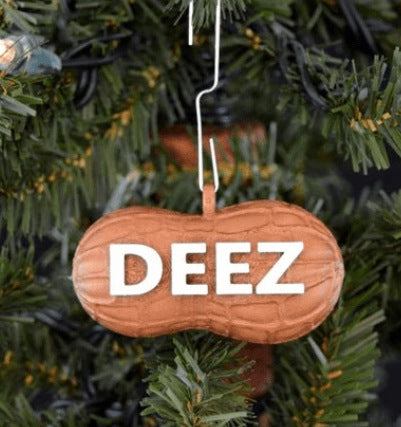Peanut-shaped brown Christmas ornament hanging on a tree, with the word "DEEZ" in bold white letters.