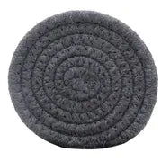 Round, charcoal gray artisan coaster made from tightly woven, thick cotton rope in a spiral pattern.