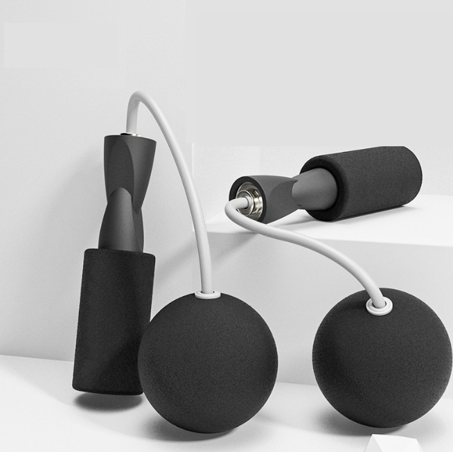 VersaRope cordless jump rope with black foam-padded handles, white cables, and weighted black spheres for home fitness.