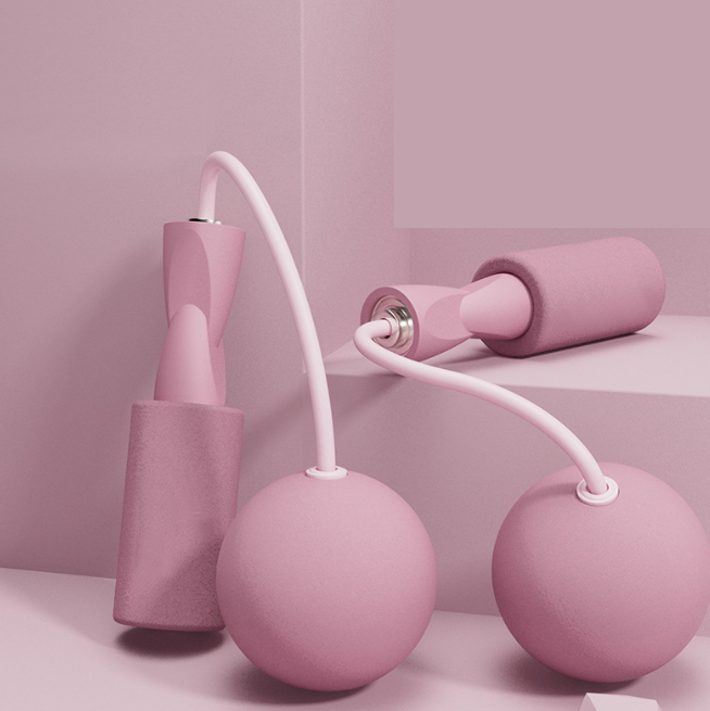VersaRope cordless jump rope with matte pink ergonomic handles and weighted spheres on a monochromatic pink background.
