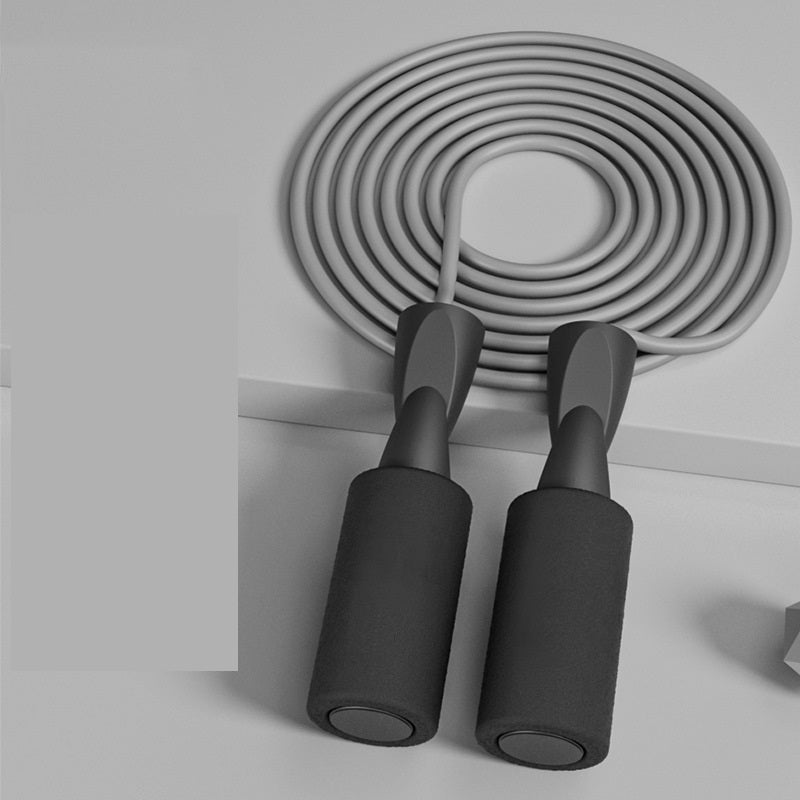 VersaRope dual-mode jump rope in monochrome grey with foam-padded ergonomic handles and a coiled, smooth rope.