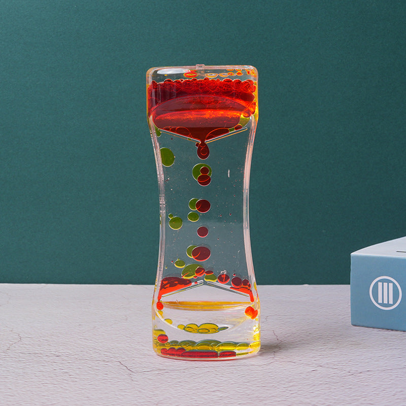 Twin tone liquid motion timer featuring red and yellow bubbles dripping through clear acrylic on a dark green background.