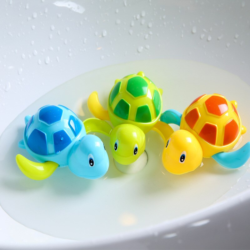 Three colorful turtle bath toys (blue, green, and yellow) floating in a white basin.