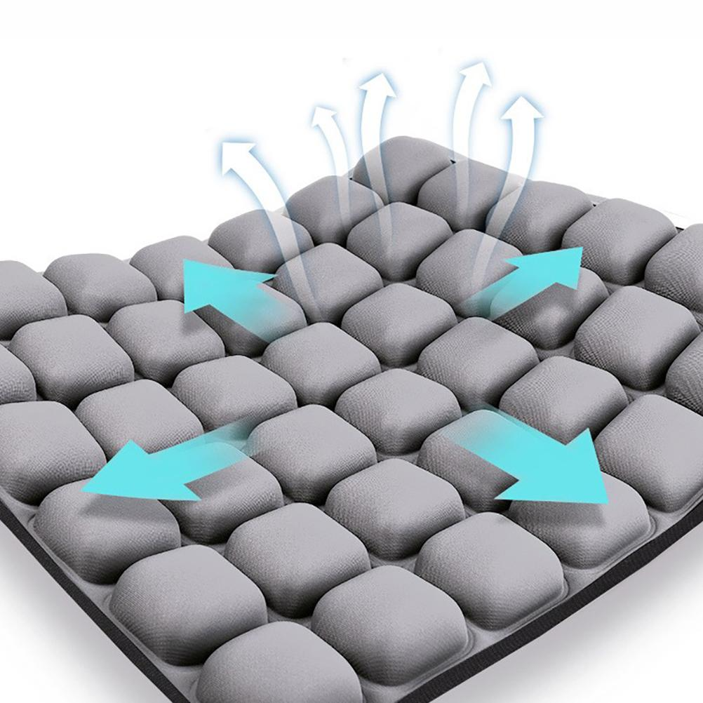 Grey ergonomic seat cushion with a grid of individual air cells and blue arrows indicating ventilation and air flow.