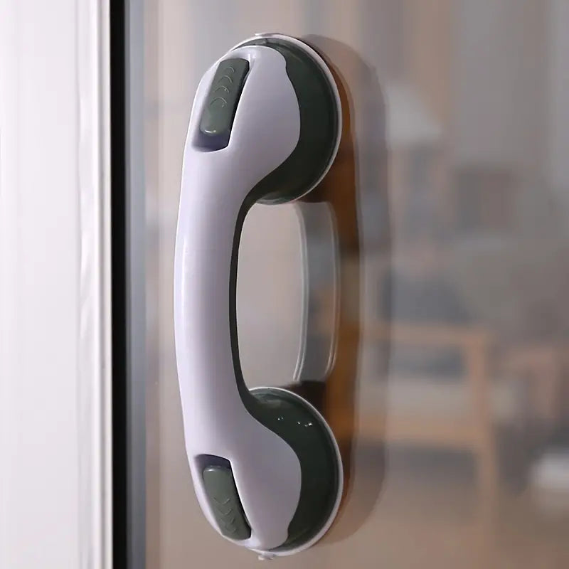 White and gray suction cup safety grip bar mounted vertically on a glass surface.