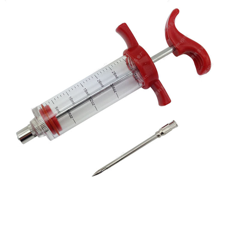 Clear plastic BBQ marinade injector with red handle and plunger, featuring measurement markings and a detachable needle.