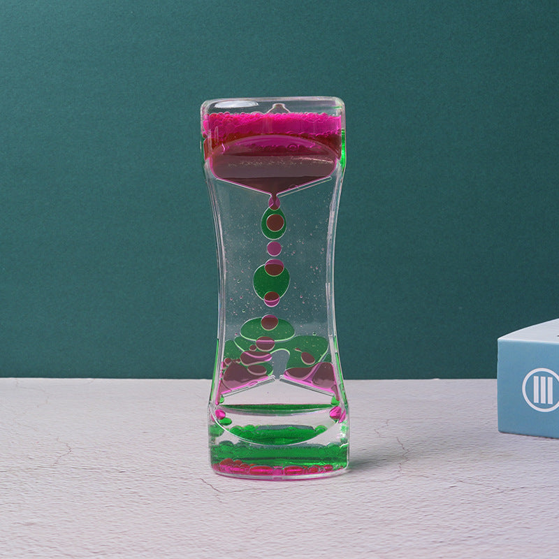 Acrylic twin-tone liquid motion timer with pink and green droplets floating inside a clear, hourglass-shaped container.