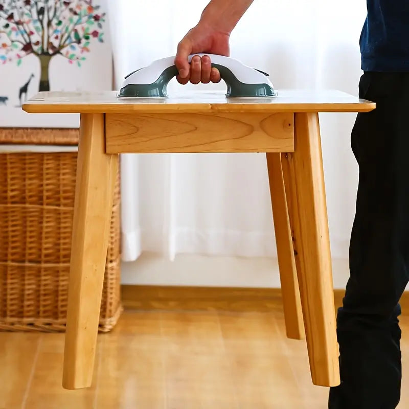 White and grey suction grip handle holding up a small wooden side table.