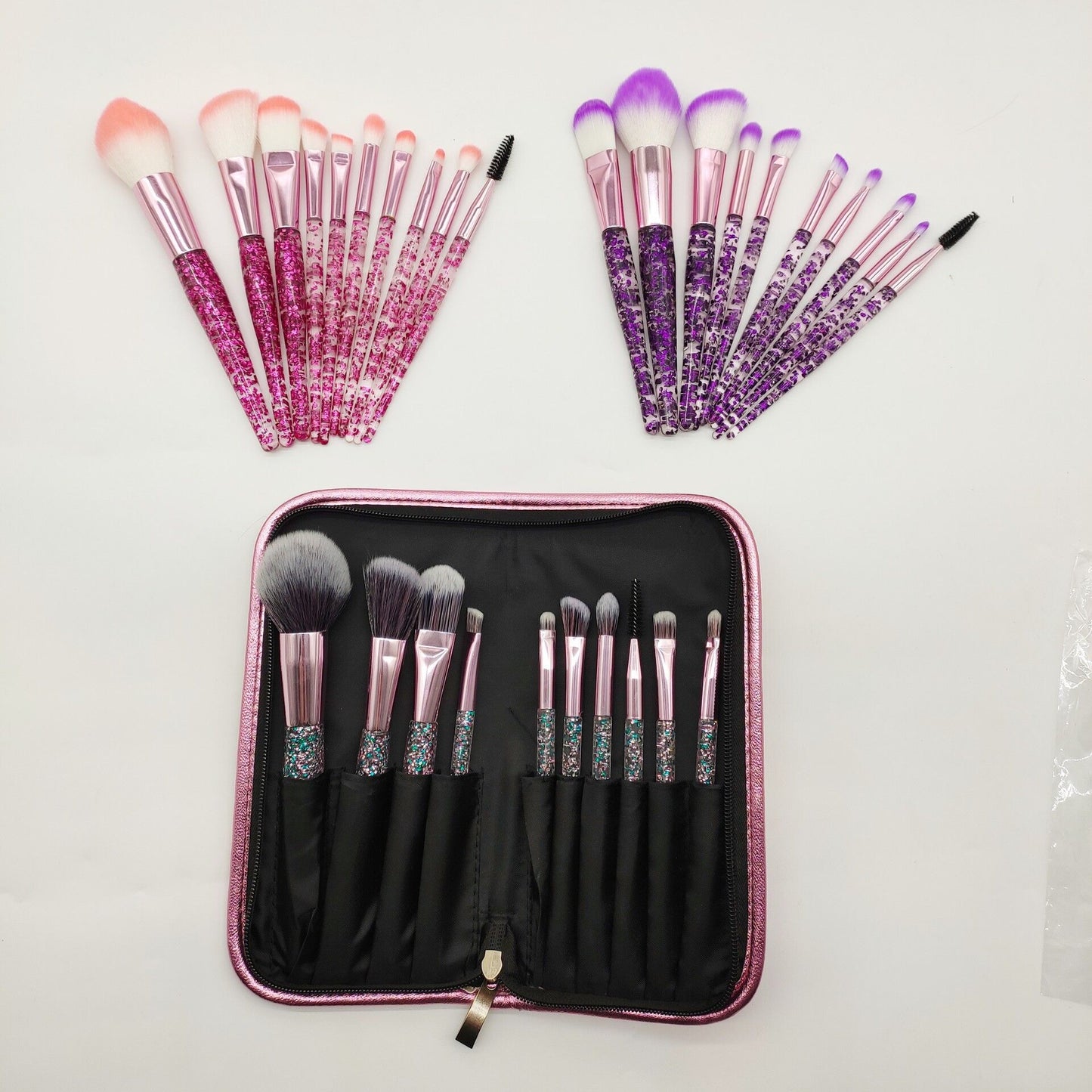 Two sets of colorful makeup brushes with glittery handles and a matching pink carrying case.