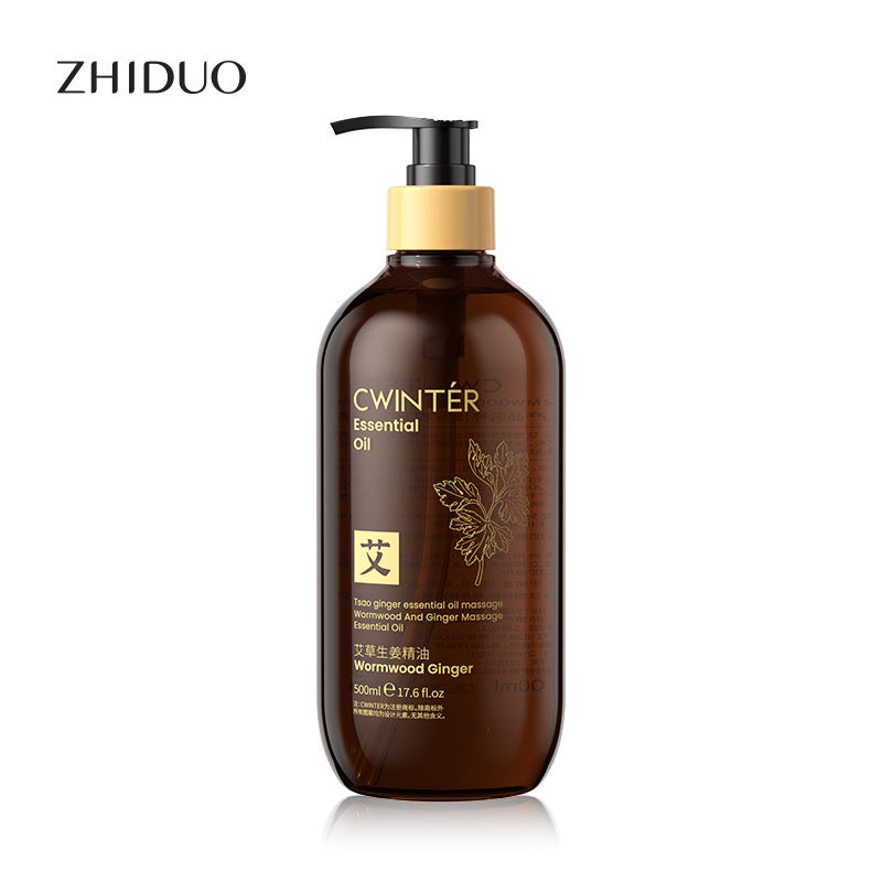 500ml amber bottle of Cwinter ginger and wormwood massage oil with a gold pump, featuring botanical label art.