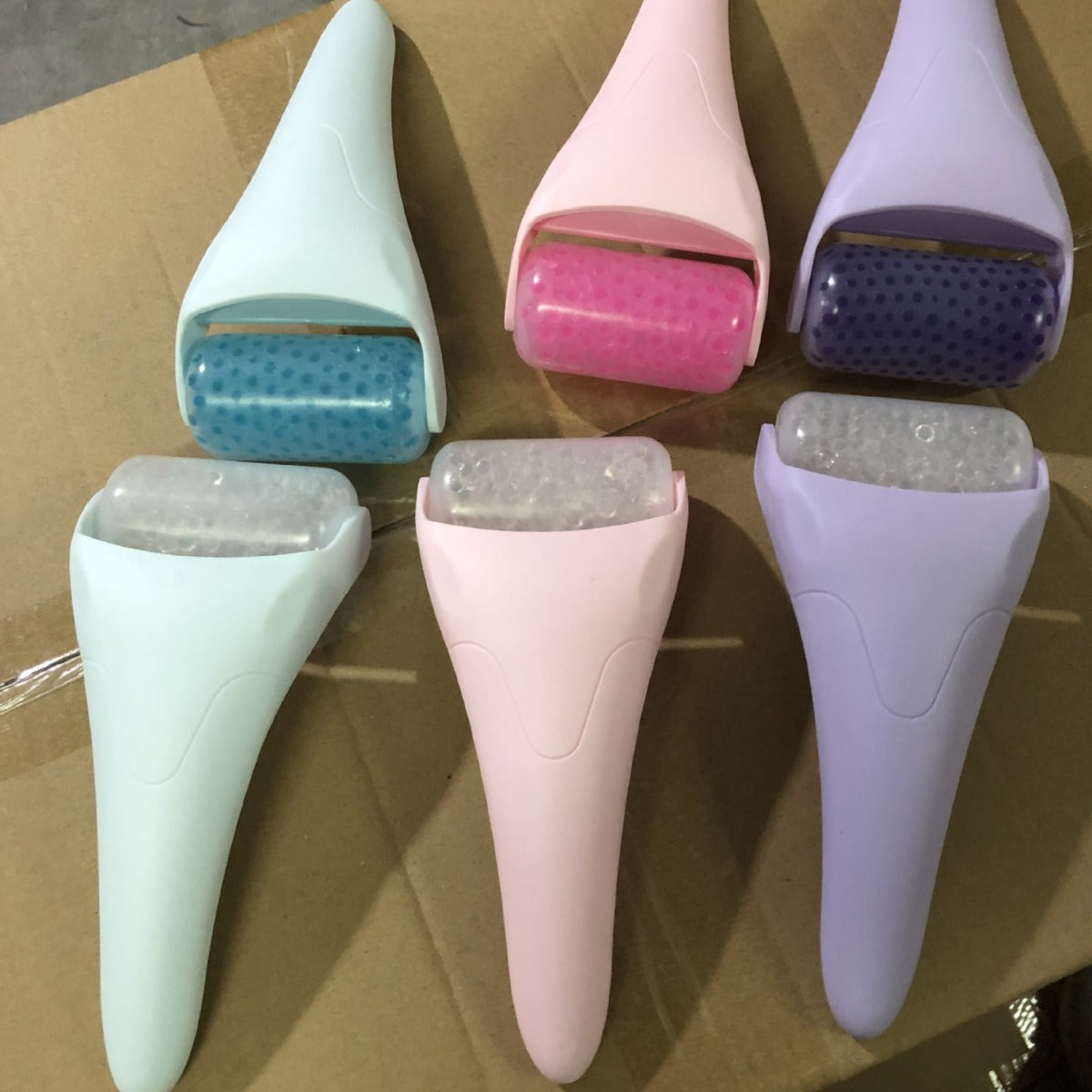 Six Chill Glide facial ice rollers in pastel blue, pink, and purple, featuring textured, dimpled cooling heads.