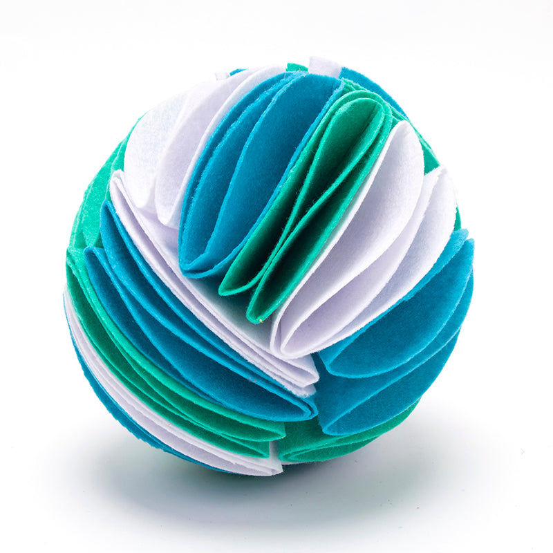 Interactive dog snuffle ball made of layered white, teal, and blue felt fabric strips on a white background.