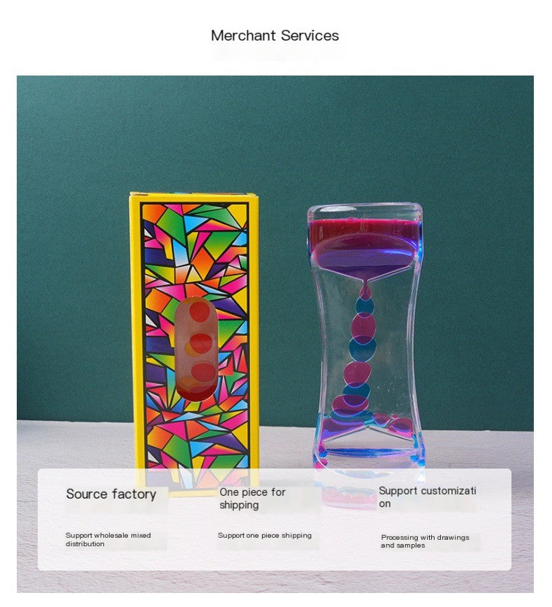 Liquid motion bubbler timer next to its box with a vibrant, multi-colored stained-glass geometric pattern.