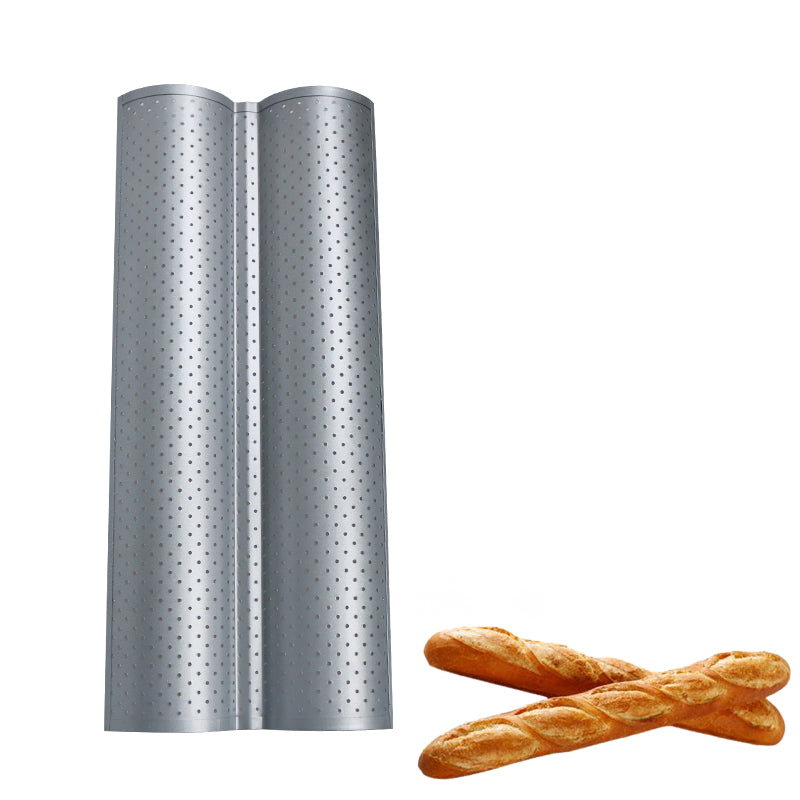 Silver, perforated metal baguette pan with two troughs next to two golden-brown French loaves on a white background.