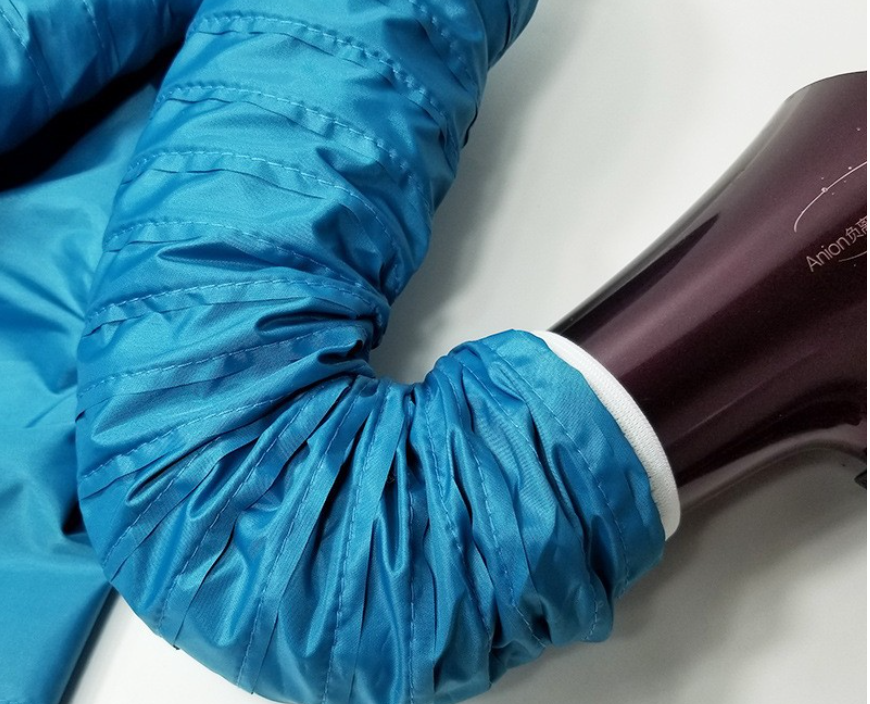 Blue, pleated flexible tube attached to a dark brown handheld pet grooming dryer against a white background.