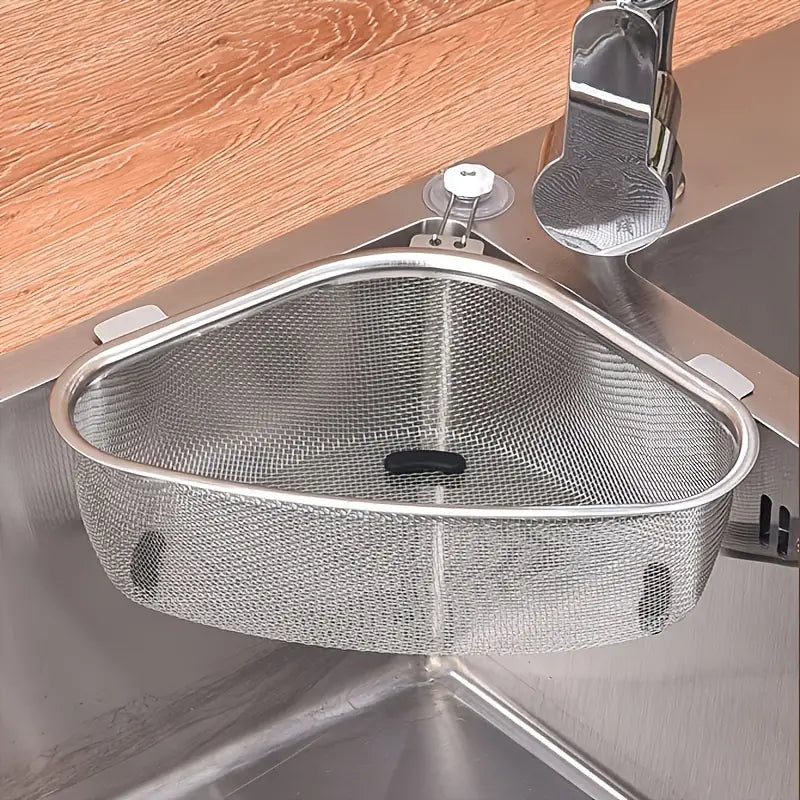 Triangle stainless steel mesh kitchen sink strainer with suction cups installed in the corner of a metal sink.