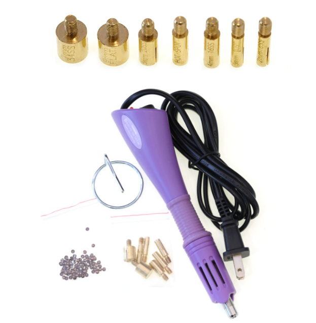 Purple handheld craft heat tool with power cord, seven gold screw-on tips, metal stand, and a bag of small crystals.