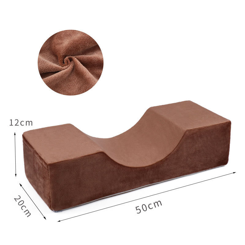 Brown velvet U-shaped lash pillow, 50x20x12cm, featuring a contoured headrest and fabric close-up inset.