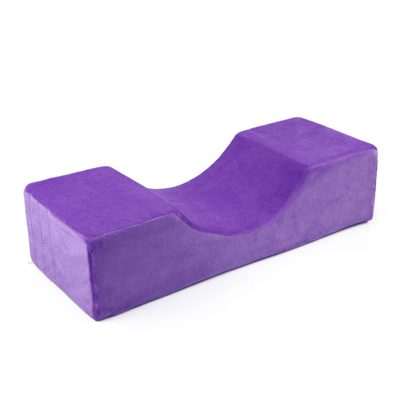 Purple velvet U-shaped ergonomic lash pillow with a contoured neck support design on a white background.