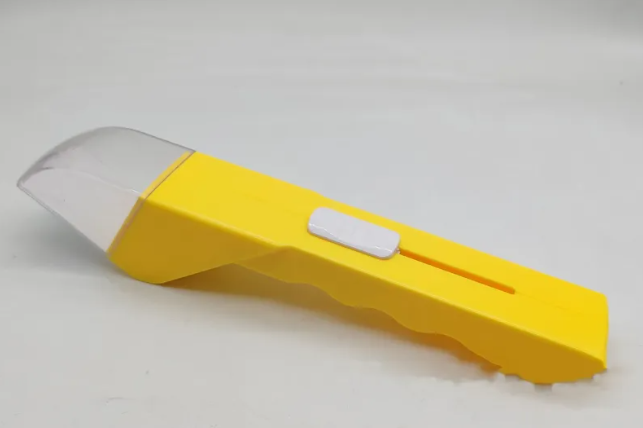 Bright yellow plastic bug catcher with a clear, domed head and a white sliding trigger on a contoured handle.