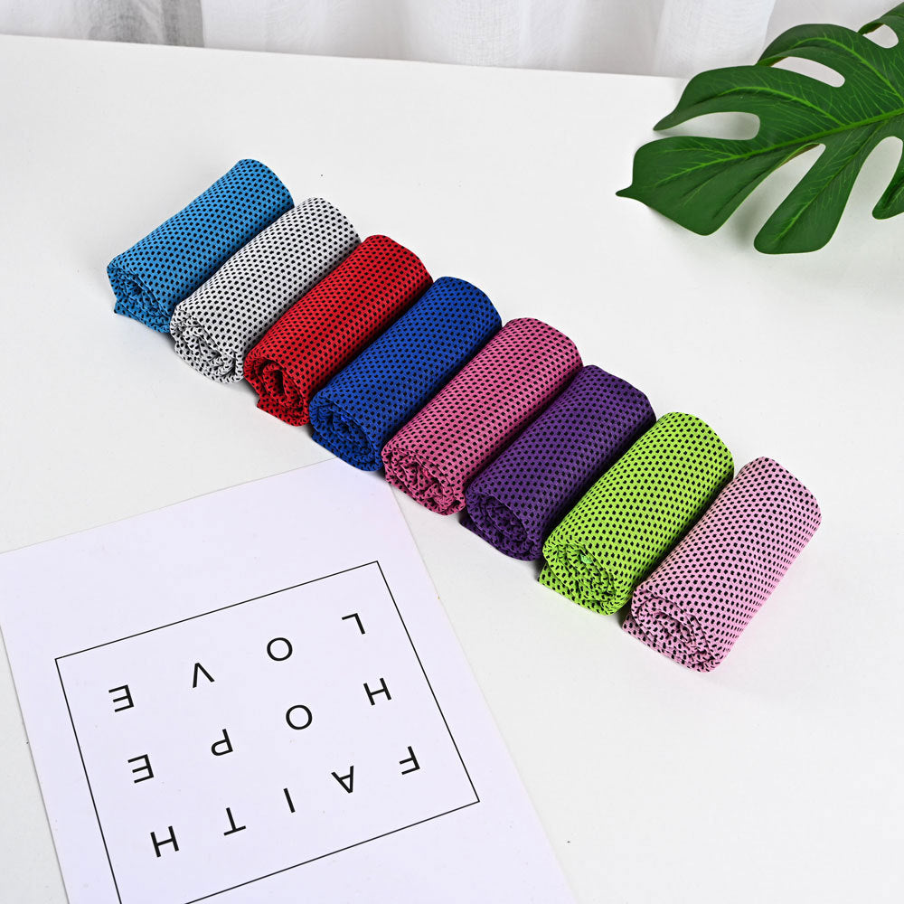 Eight rolled SwiftCool mesh outdoor activity towels in a variety of vibrant colors arranged on a white surface.