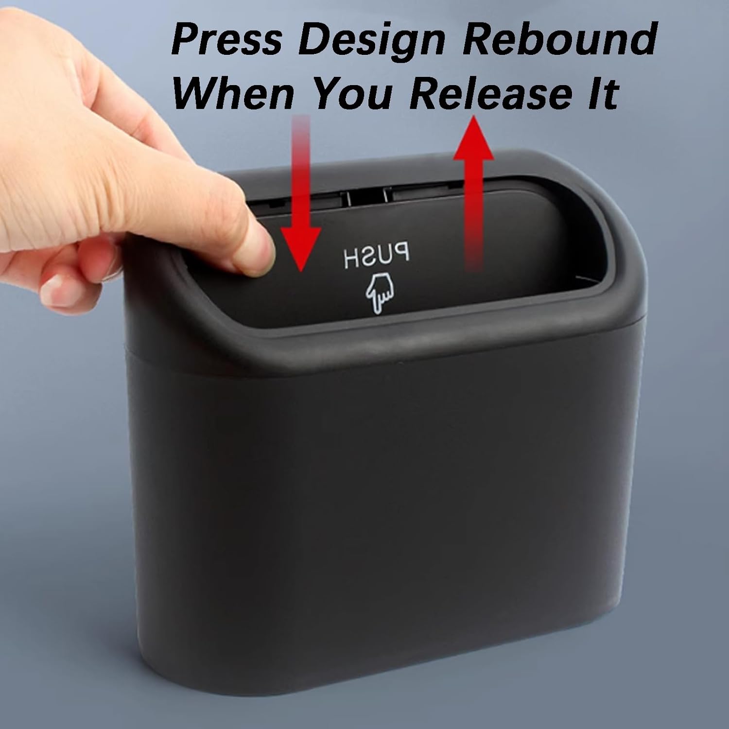 Hand pressing down on a black, rectangular, spring-loaded car bin with a "PUSH" icon on the lid.