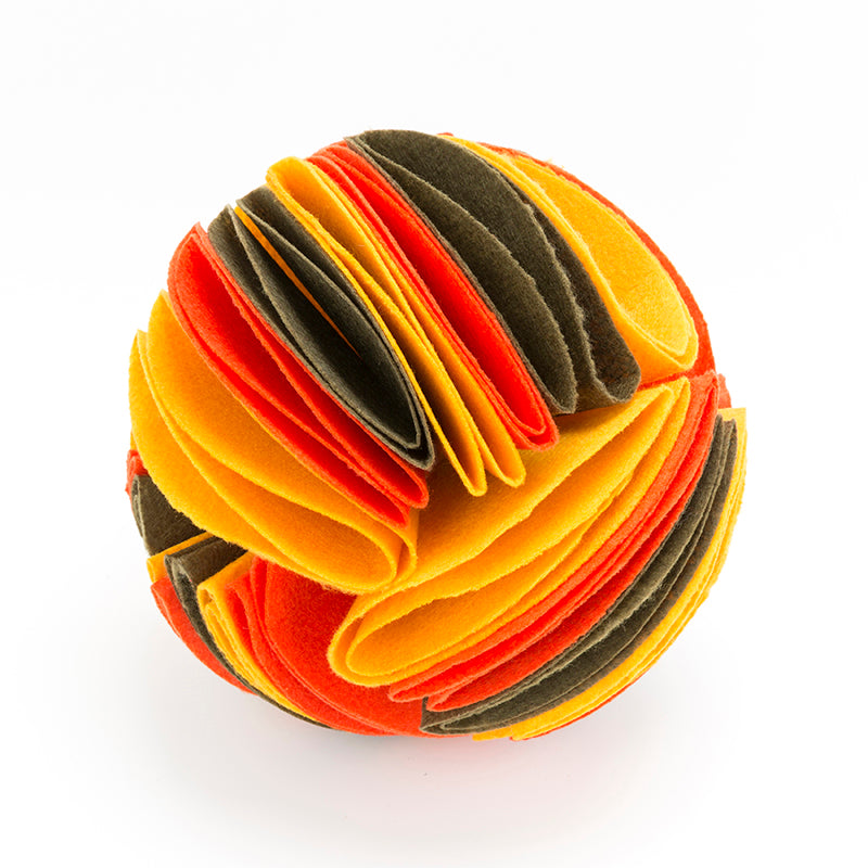 Interactive dog snuffle ball made of layered, felt-like fabric in vibrant shades of orange, yellow, and dark olive.