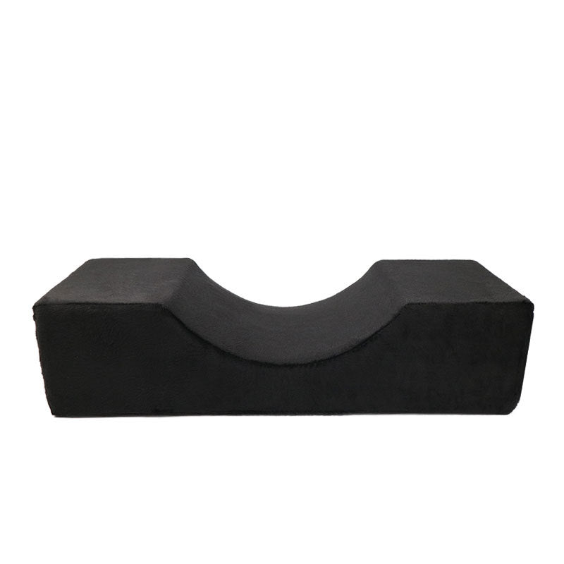 Black U-shaped memory foam lash pillow with a soft, velvet-textured finish, isolated on a white background.