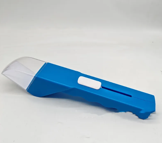 Blue portable bug grabber tool with a clear plastic end and a sliding white thumb control on a wavy handle.