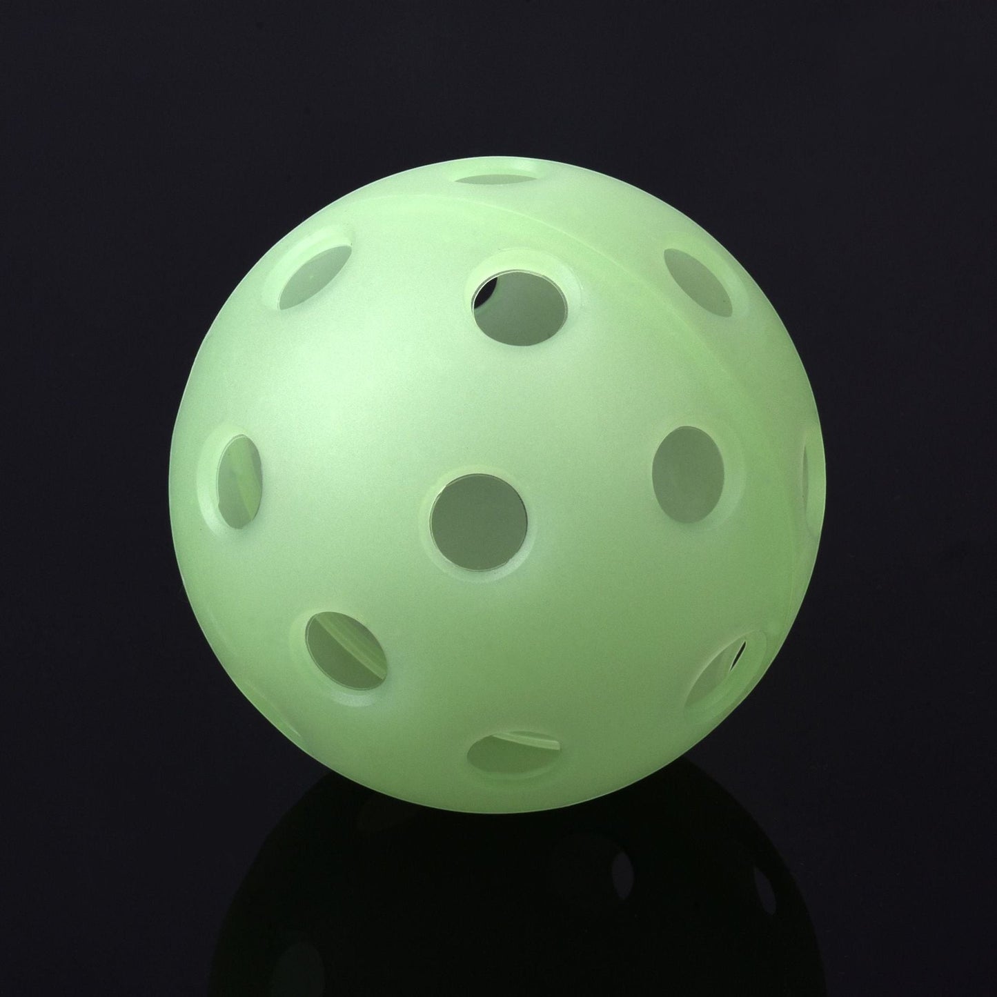 Creative Vault Marketplace fluorescent green pickleball with 40 holes for indoor and outdoor play on a black background