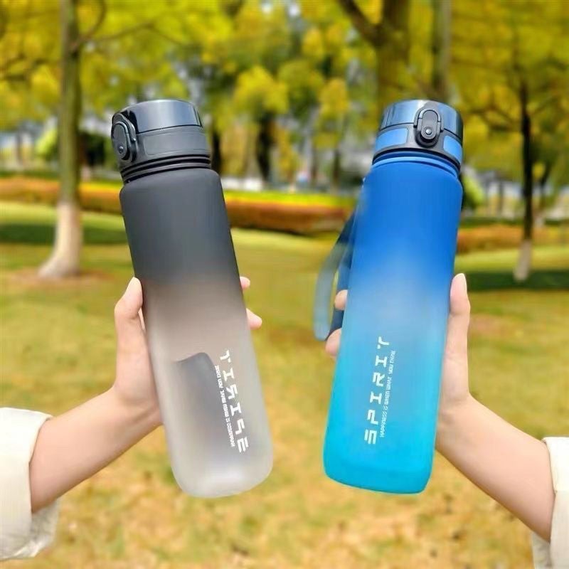 Creative Vault Marketplace gradient sports water cups in black and blue, held outdoors with a park background.
