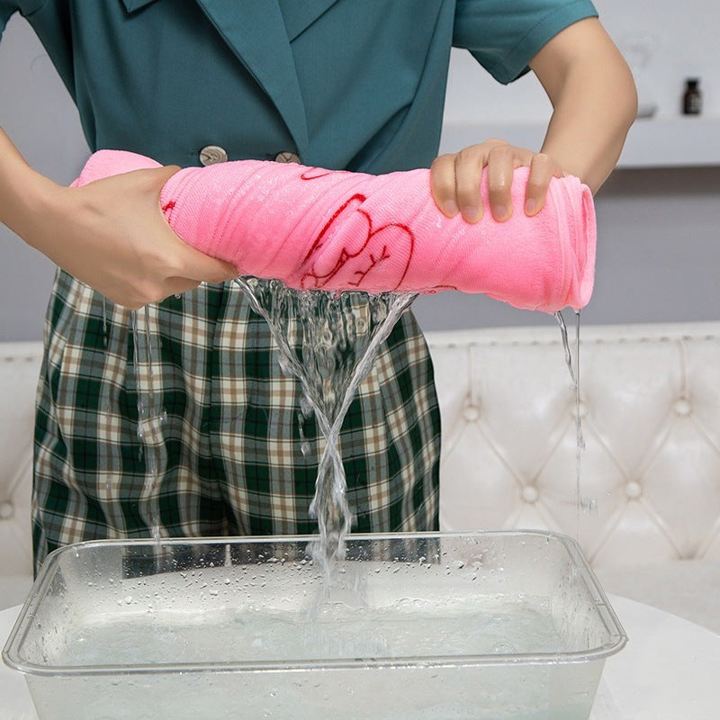 Creative Vault Marketplace pink coral fleece cartoon beach towel dress being wrung out over a water basin