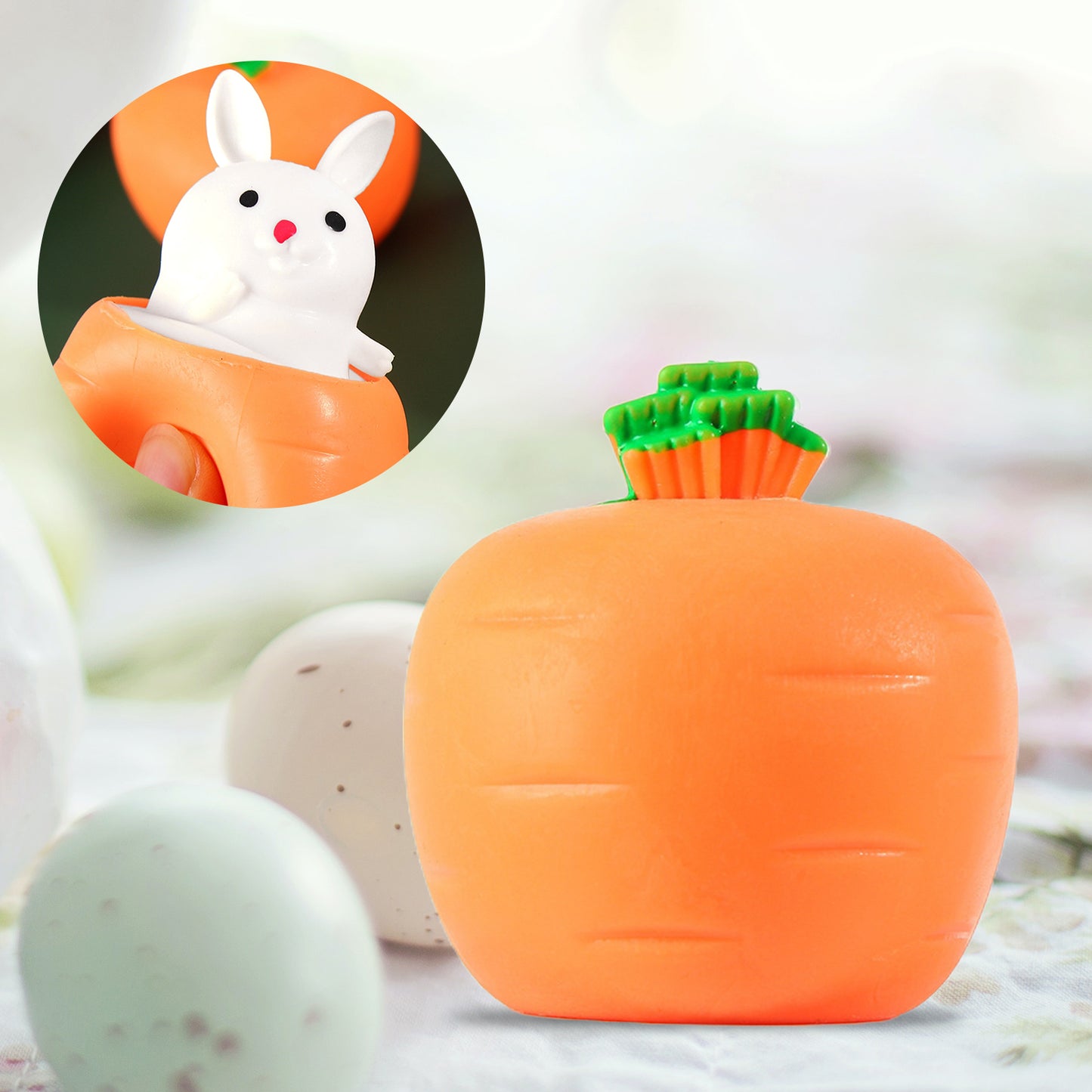 Orange carrot stress toy that pops up a small white bunny when squeezed, shown in a circular inset and main view.
