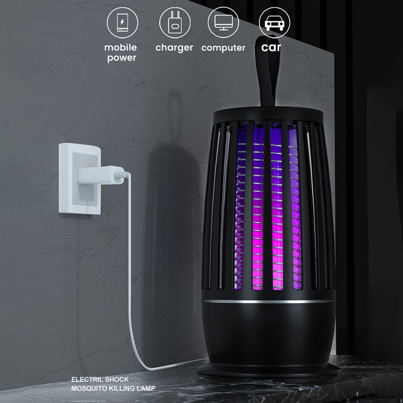 Black, cylindrical smart mosquito zapper lantern glowing with purple light, plugged into a wall charger.