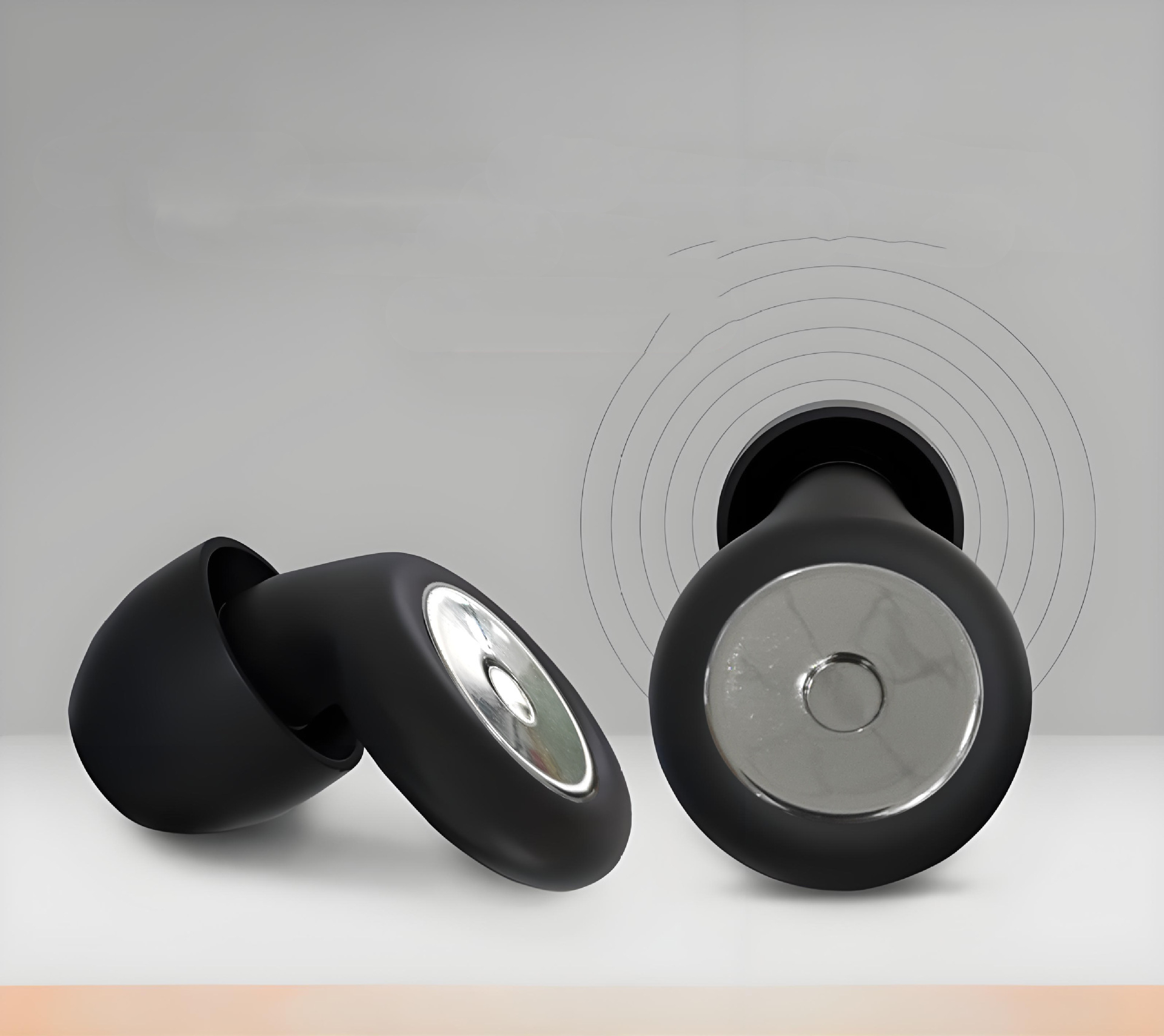 Matte black Silent Night earplugs with metallic circular centers, displayed against a neutral background.