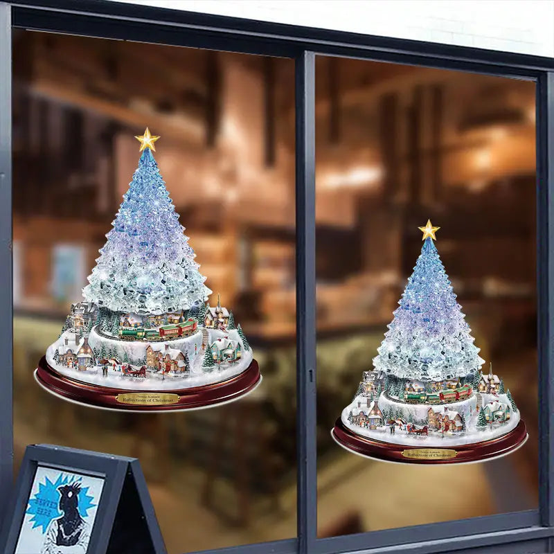 Two window decals showing Christmas tree centerpieces with rotating trains, snowy villages, and glowing gold stars.