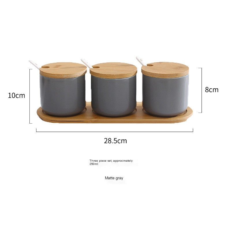 Nordic spice set with three matte gray ceramic jars, bamboo lids, spoons, and a matching bamboo serving tray.