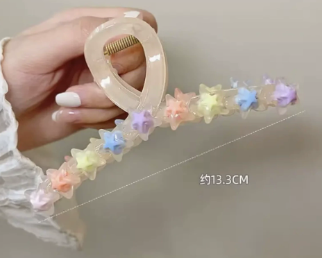 Beige translucent claw clip featuring a row of colorful pastel star accents, measuring 13.3 cm in length.