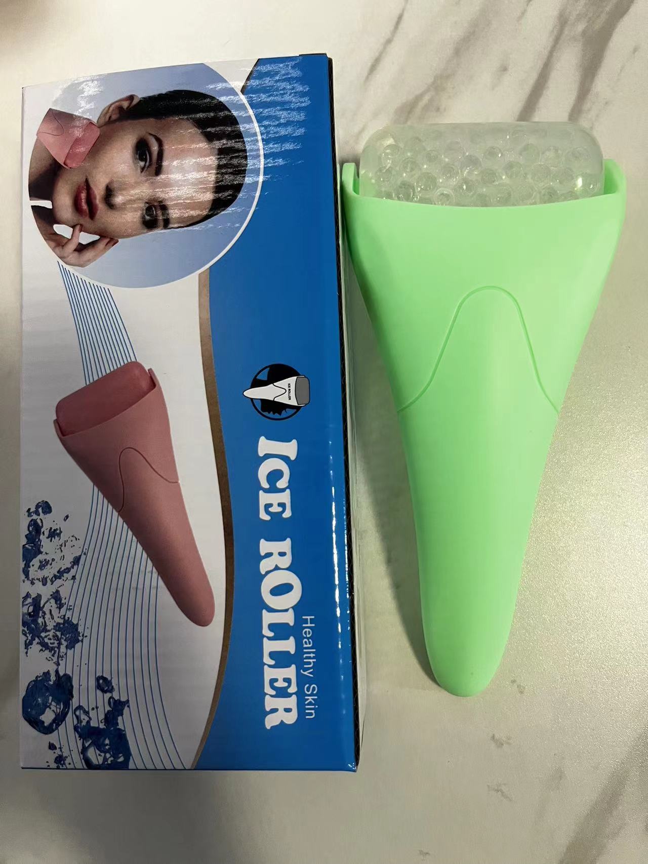Light green Chill Glide facial ice roller next to its blue retail box featuring a model and pink roller illustration.